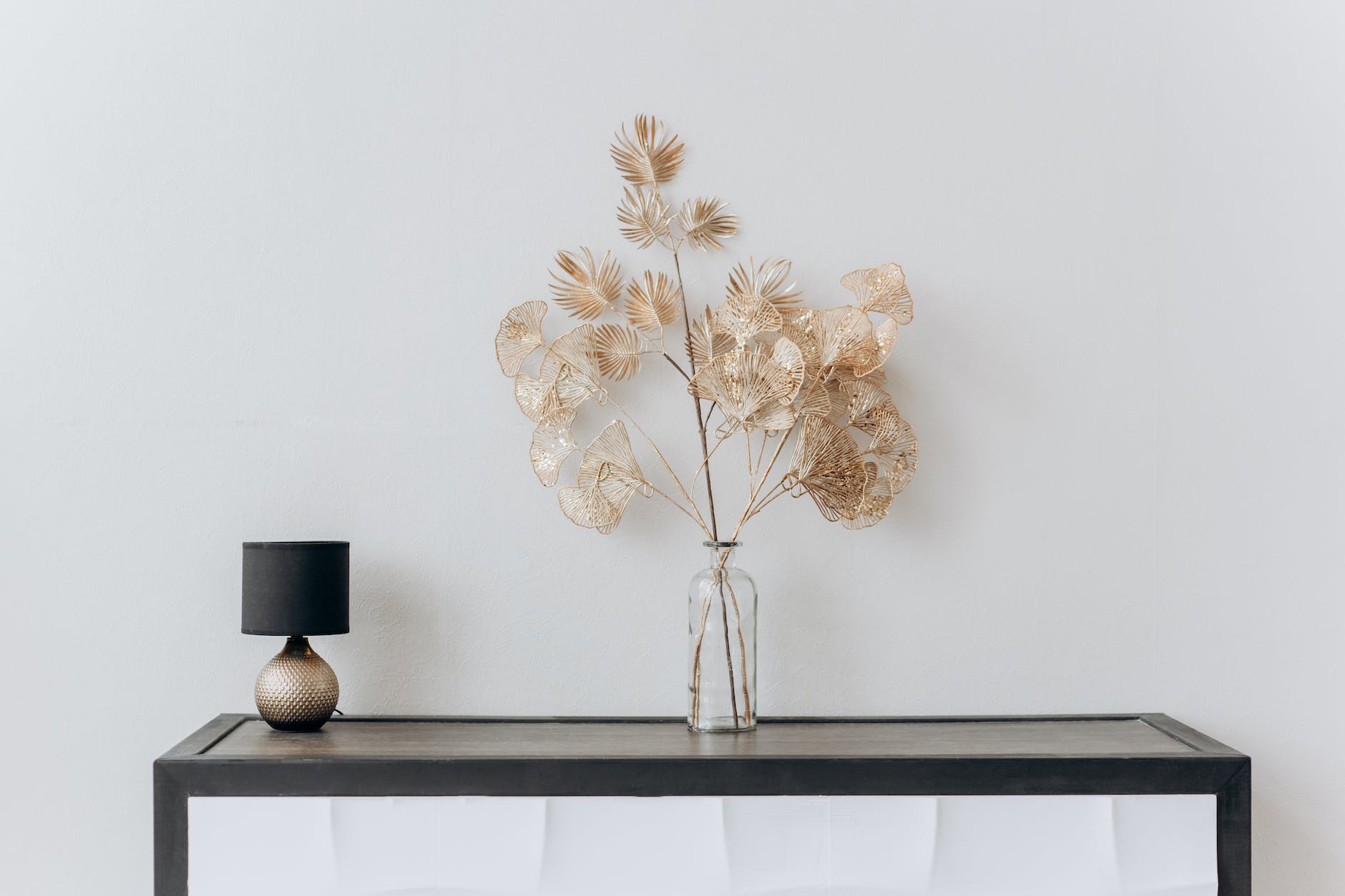 flower vase and lamp on black vase on a console table